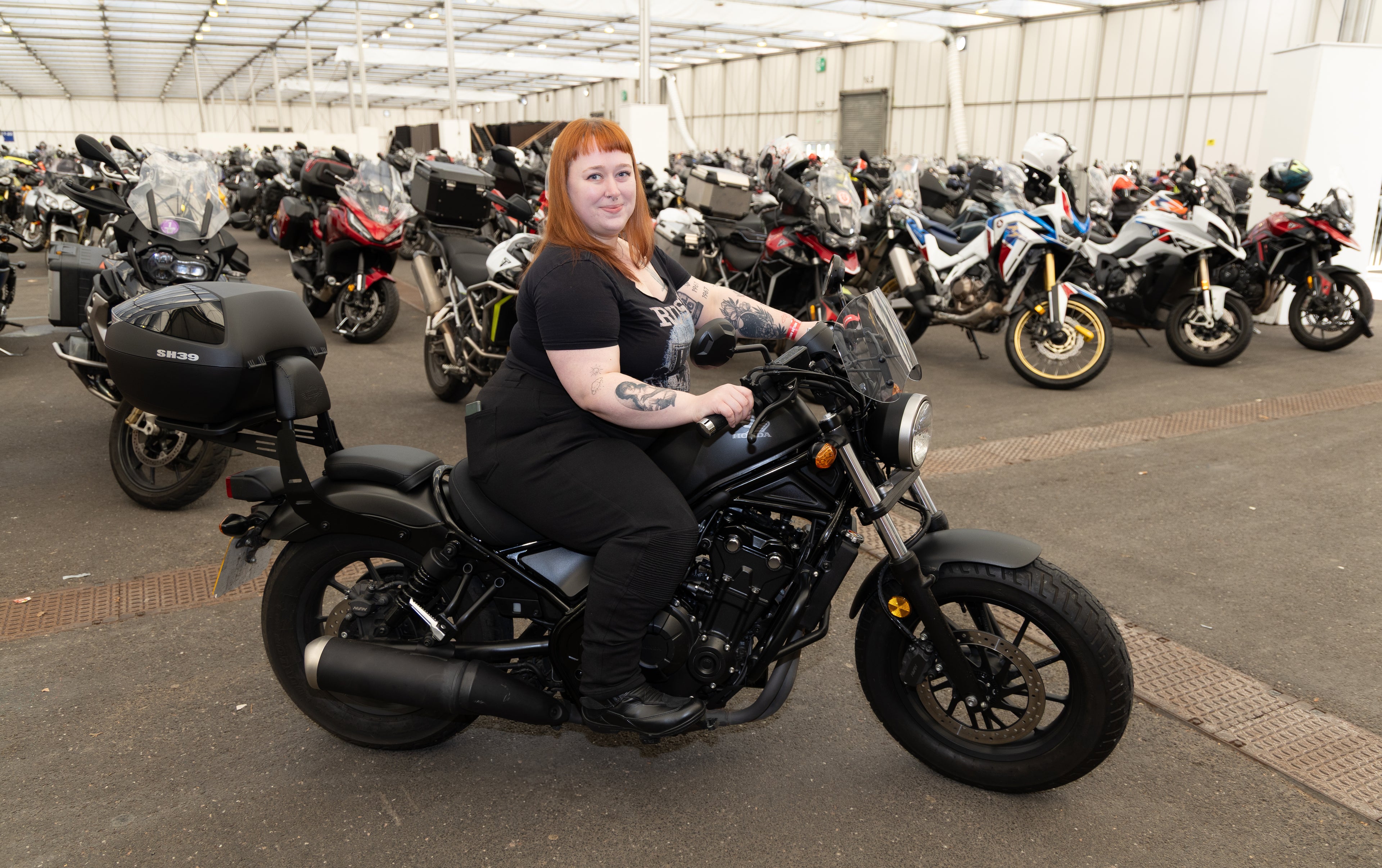 Woman sitting on a Honda Rebel motorcycle at the MCL show